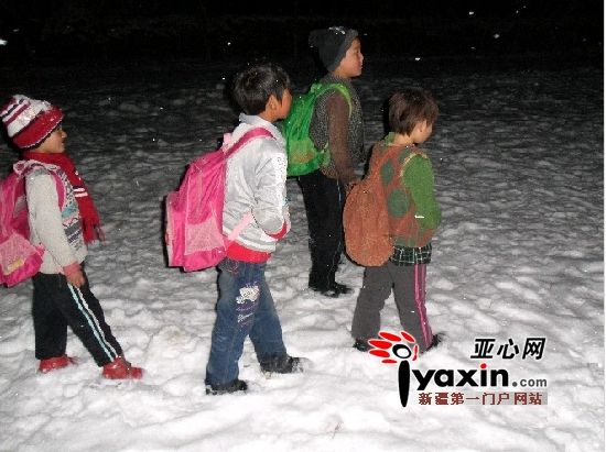 图为当地的孩子们穿着单薄的衣服步行回家